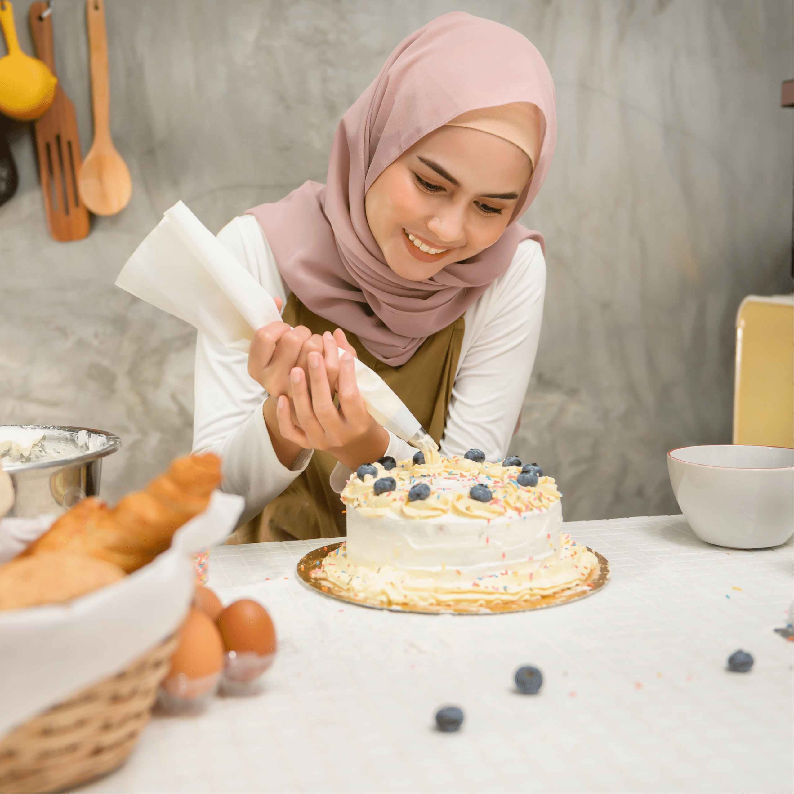 Sara piping frosting onto a homemade cake while baking in her home kitchen