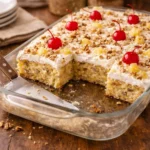 Millionaire cake sliced and partially served from a glass baking dish
